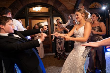 Couples and guest enjoy the warm night air as they dance under vintage bulb lighting